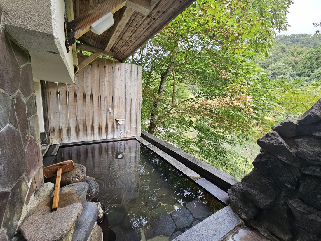 10:25 貸切露天風呂「楓之湯」。石砌浴池、木桶木杓，隔著杉木圍籬就是溪谷